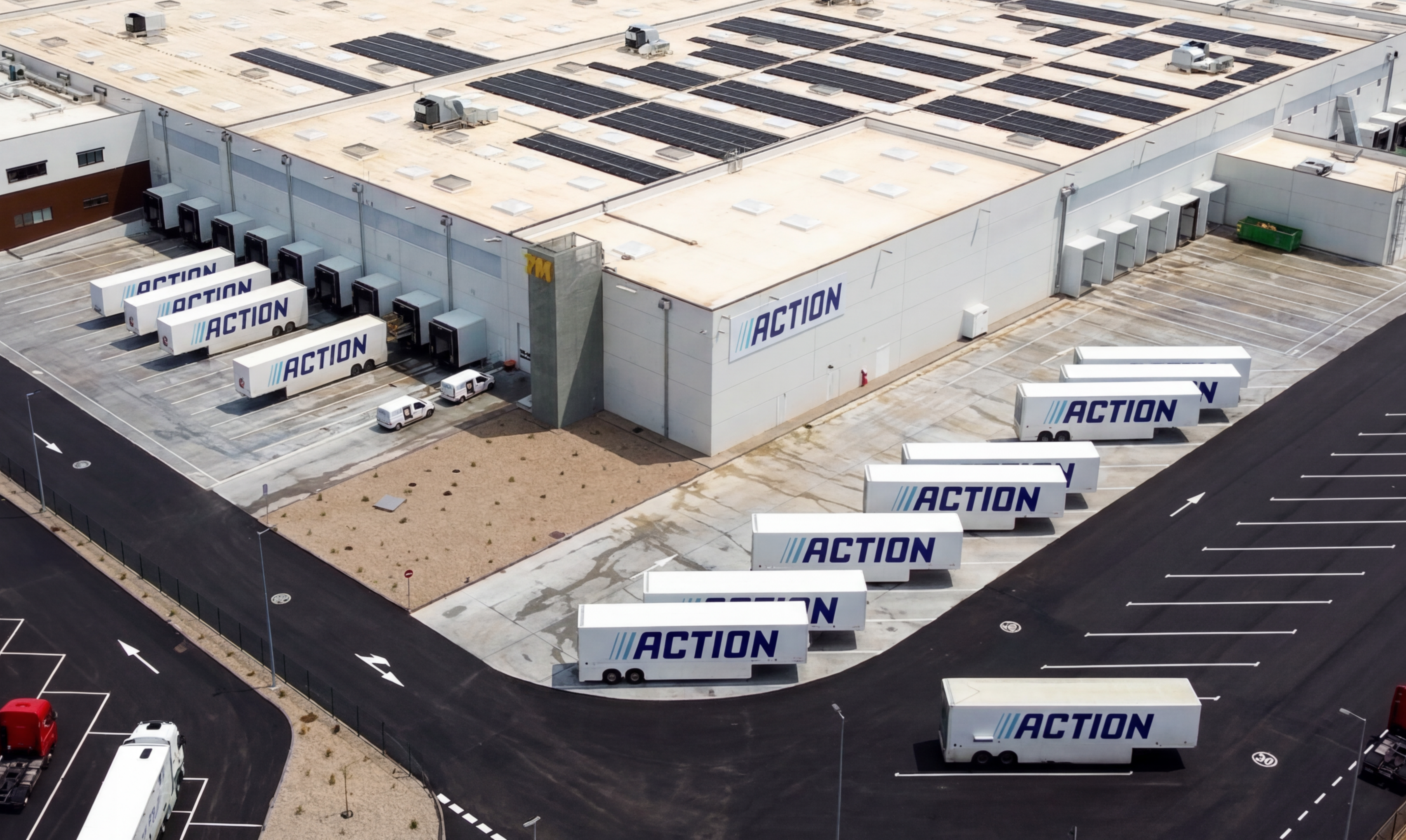Aerial view of large Action warehouse and trucks