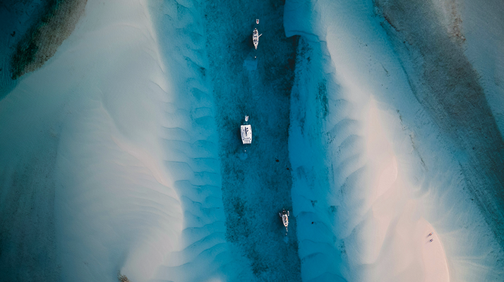 Aerial view of small boats in shallow blue water