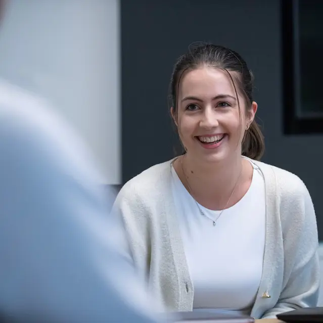 Smiling woman in professional attire during a meeting