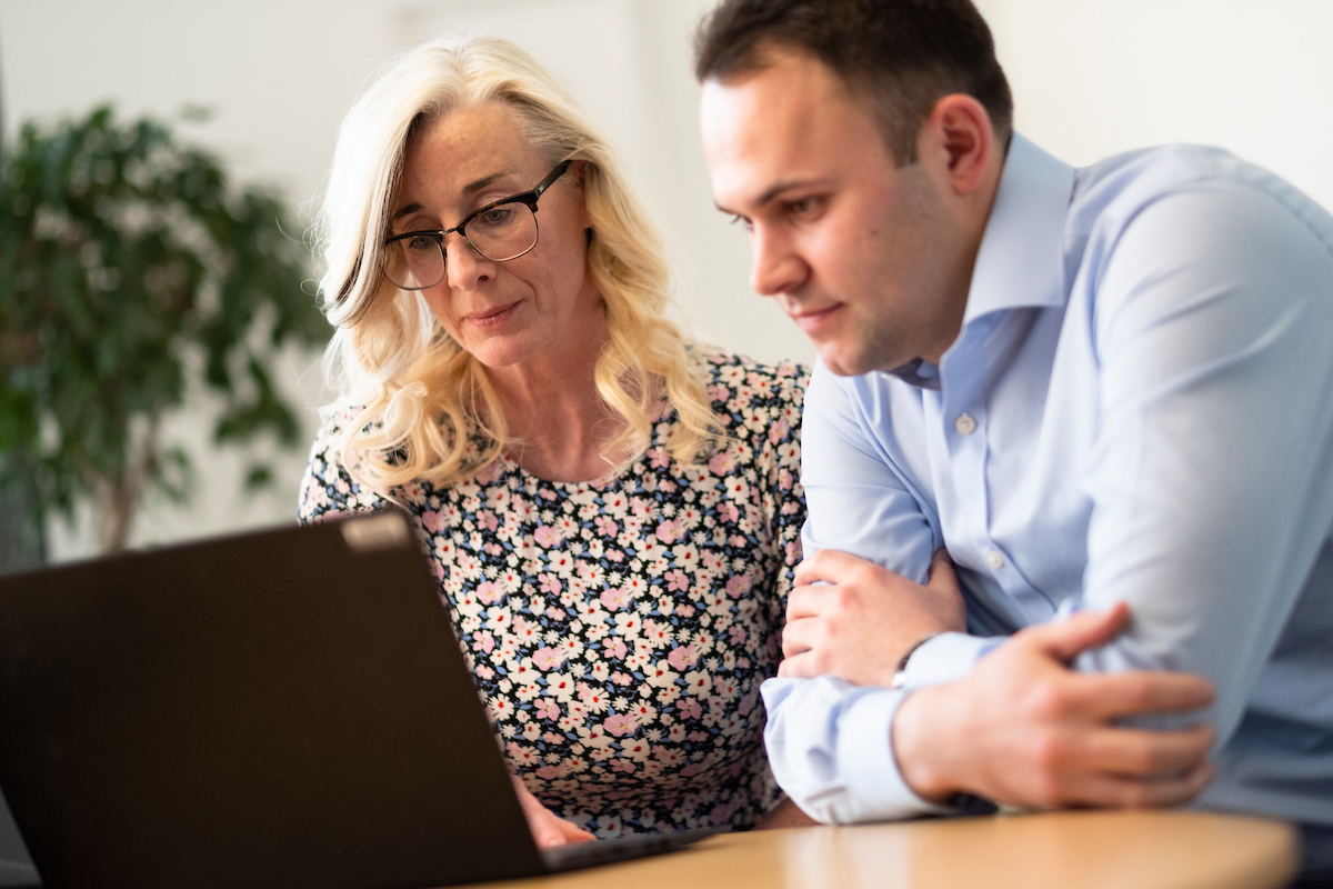 A woman and man looking at laptop together