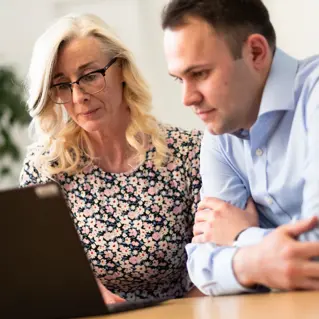 A woman and man looking at laptop together