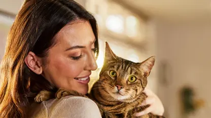 Woman smiling while holding a cat